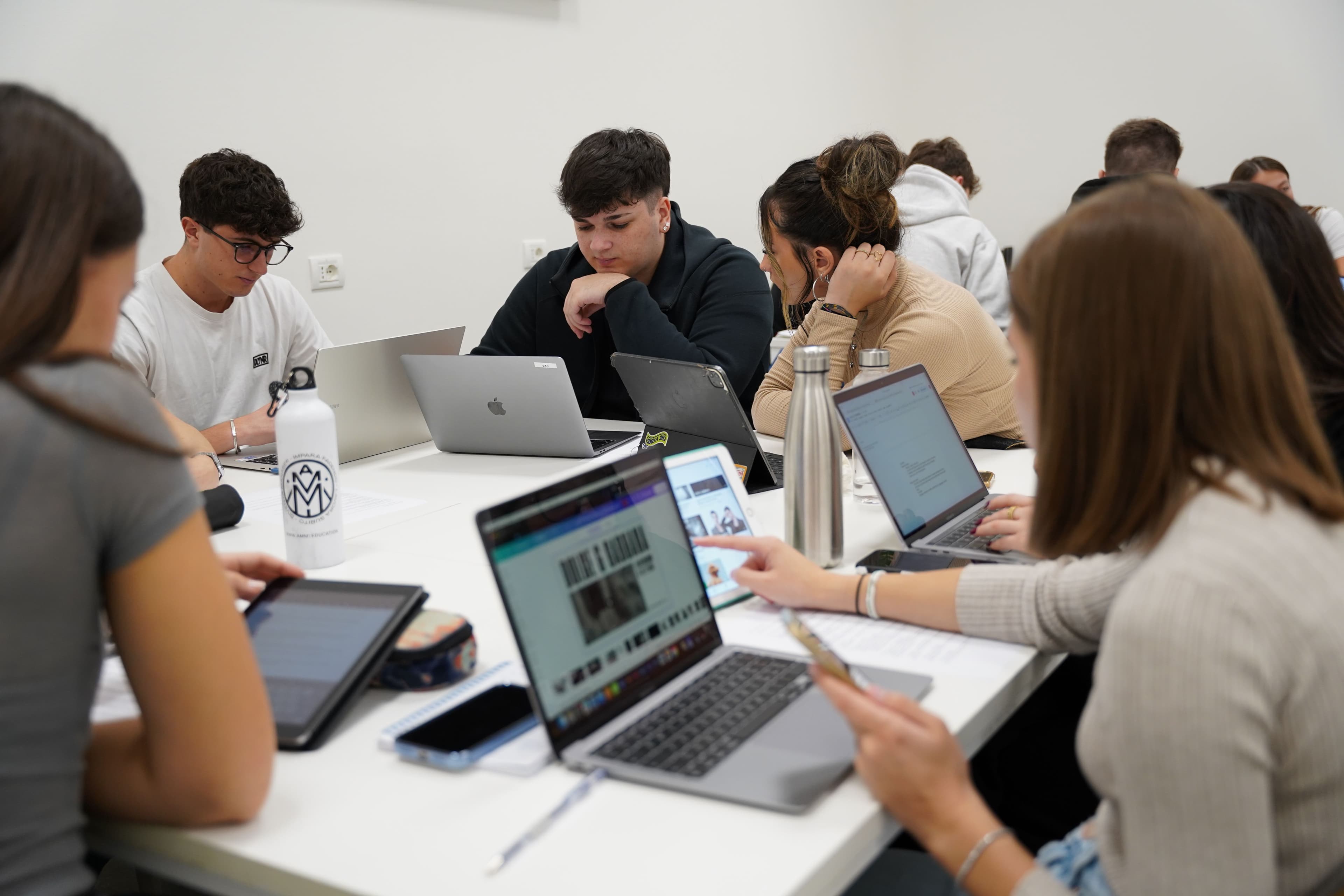 Studenti durante il corso IFTS Web design e creazione app, impegnati in attività collaborative con laptop e tablet in aula, concentrati su progetti digitali.